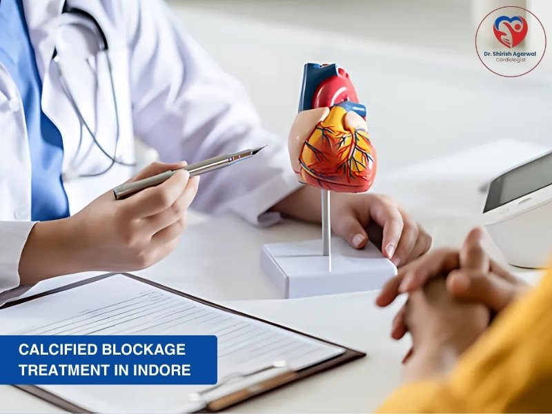 Doctor explaining calcified blockage treatment in Indore with heart model at clinic
